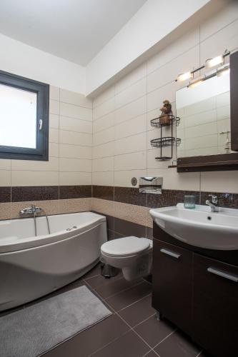 a bathroom with a tub and a toilet and a sink at Sea View Apartment in Rhodes Town