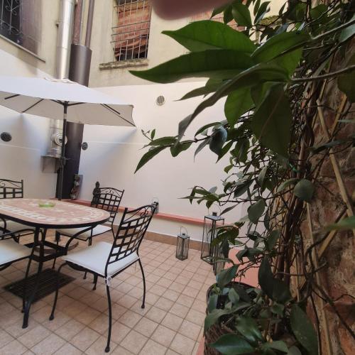 a patio with a table and chairs and a plant at Nell'antico ghetto ebraico in Ferrara
