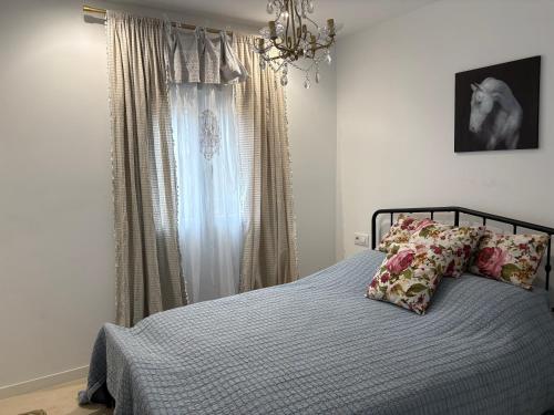 a bedroom with a bed with pillows and a window at La Casa del Encinar in Valdemorillo