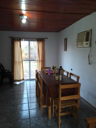 a dining room with a table and chairs and a window at Cabañita La Paz Villa Sanagasta in Villa Bustos