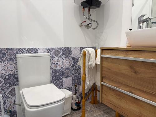 a bathroom with a toilet and a sink at La Casa del Encinar in Valdemorillo