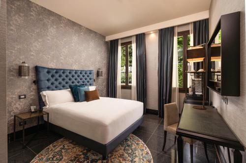 a hotel room with a bed and a desk and window at The Venice Times Hotel, Vignette Collection by IHG in Venice