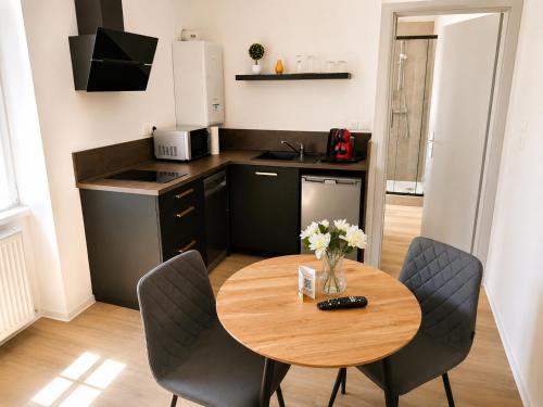 a small kitchen with a wooden table and chairs at Le Clos d'Ingersheim in Ingersheim