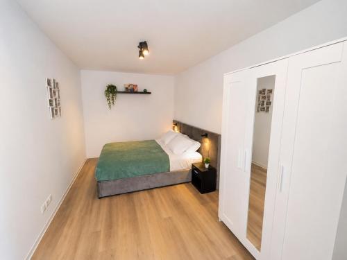 a bedroom with a bed and a wooden floor at Le Clos d'Ingersheim in Ingersheim