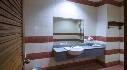 a bathroom with a sink and a mirror at Phuphaya Resort Pattaya in Pattaya South