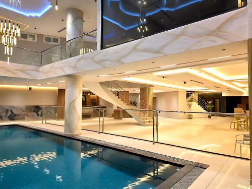 a swimming pool in a building with a staircase at Transit Hotel in Juba