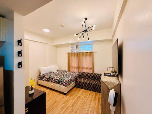 a bedroom with a bed and a chandelier at JFam Suites, C3-9D Studio, Up To 4 Pax in Biñan