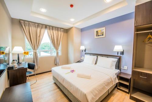 - une chambre avec un lit, un bureau et une fenêtre dans l'établissement inHotel Inanam, à Kota Kinabalu