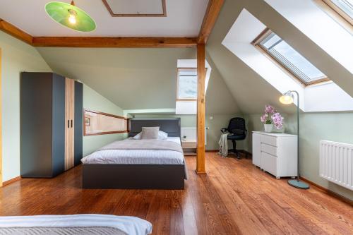 a attic bedroom with a bed and a desk at Vila Fénix in Kutná Hora