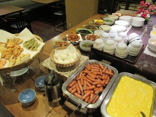 a buffet of food with carrots and other foods at Hotel Crown Hills Kokura in Kitakyushu
