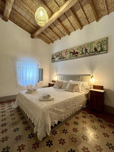a bedroom with a bed with a white bedspread at Palazzo Ma.Ri.Lu. in Càbras