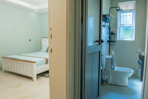 a bedroom with a bed and a toilet in it at E- Residence in Gulu