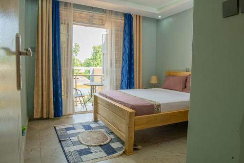 a bedroom with a bed and a balcony at E- Residence in Gulu