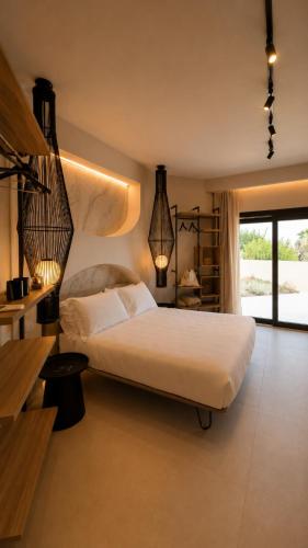 a bedroom with a large white bed and a window at Naim Boutique Hotel in Costa Rei