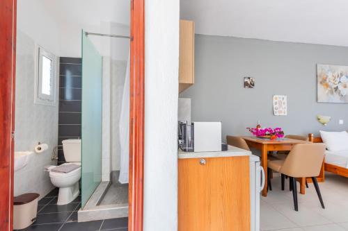 ein Badezimmer mit Waschbecken und Toilette sowie ein Schlafzimmer in der Unterkunft Studios Nina in Amoopi