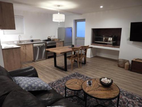 a kitchen and living room with a couch and a table at Skye in Paternoster