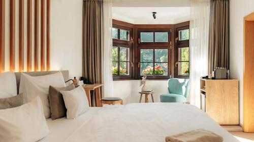 a bedroom with a white bed and a blue chair at Boutique Hotel Soyka in Špindlerův Mlýn