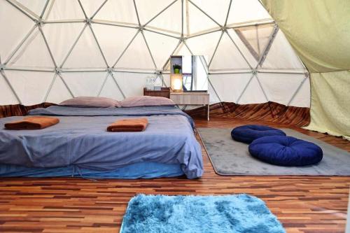 a bedroom with a bed and two blue pillows in a tent at MonPhuView MonJam ม่อนภูวิว ม่อนแจ่ม in Mon Jam