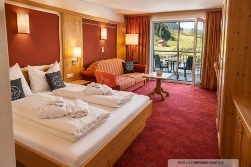 a hotel room with two beds and a living room at Sporthotel Auhof in Kappl
