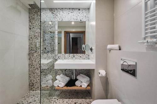 a bathroom with a shower and a sink and a toilet at Hotel Zator in Zator