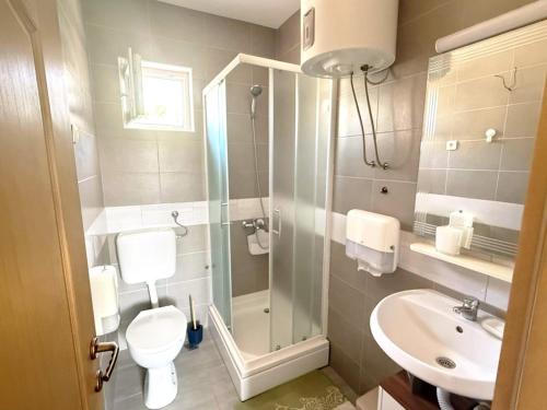 a bathroom with a shower and a toilet and a sink at Apartment Lore in Primošten
