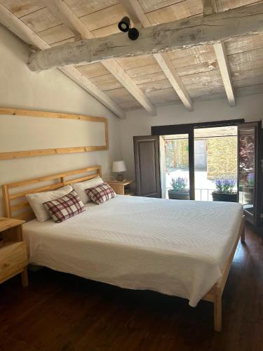 a bedroom with a large bed with white sheets at Cal Toni de Vilallobent in Vilallovent
