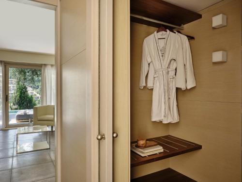 a white robe hanging on a wall at Atlantica Grand Mediterraneo Resort - Adults Only in Kompítsion