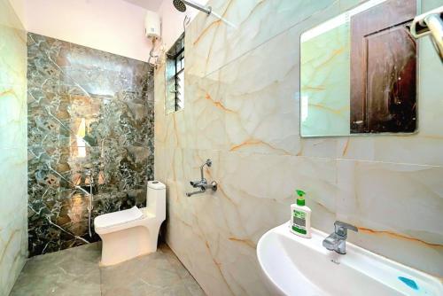 ein Badezimmer mit Waschbecken, Toilette und Spiegel in der Unterkunft II EMPYREAN STAYS II SU CASA VILLA II 4BHK II AC II PRIVATE POOL Il in Lonavla