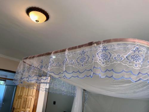 a white curtain on a ceiling in a room at Princess selection suites in Wakiso
