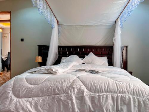 a bedroom with a white bed with a canopy at Princess selection suites in Wakiso
