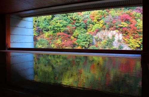 a view from a window of a colorful forest at Enraku in Kurobe