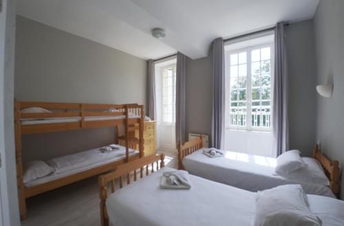 a room with three bunk beds and a window at Château du Baffy in Colombiers-sur-Seulles