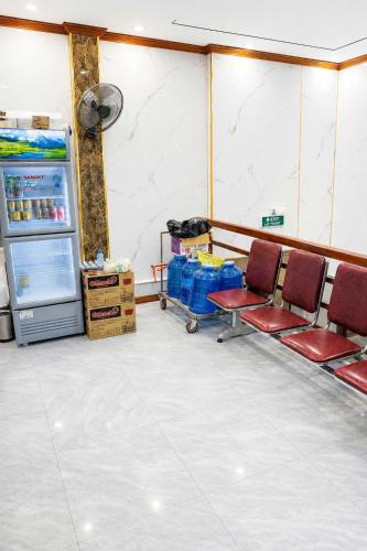 a room with two chairs and a refrigerator at Minh Anh Hotel Nghệ An in Vinh