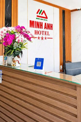 a glass counter with flowers and a hotel sign at Minh Anh Hotel Nghệ An in Vinh