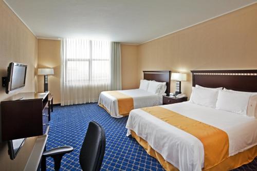 a hotel room with two beds and a flat screen tv at Holiday Inn Express Mexico Santa Fe by IHG in Mexico City