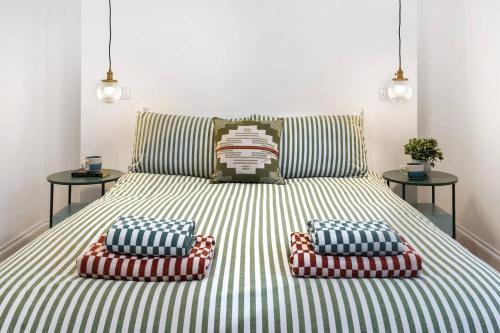 a bed with two pillows on it with two tables at Panoramic harbour views Morva in Falmouth