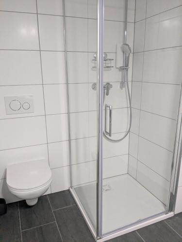 a shower with a glass door next to a toilet at Nassfeldpass Pistenblick in Sonnenalpe Nassfeld