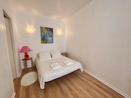 a small bedroom with a bed and a lamp at Charmant Duplex climatisé, Centre de Cahors in Cahors