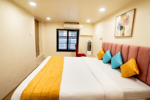 a bedroom with a large bed with yellow and blue pillows at Fit Haus - A Boutique Hotel in Kolkata