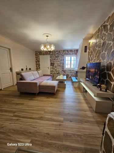 a living room with a couch and a stone wall at PELION HORIZON houses in Agios Ioannis Pelio