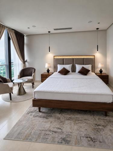 a bedroom with a large bed and a chair at The Vista 1BR by Winchester in Mall of Islamabad F-7 Margalla & City Views in Islamabad