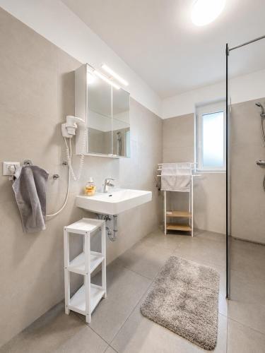 a white bathroom with a sink and a shower at TO-HAD, Modern Apartments next to U-bahn with free Wifi in Vienna