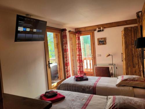 a hotel room with two beds and a window at Charming Chalet w/ Mountain & Slope Views, Jacuzzi in Vars