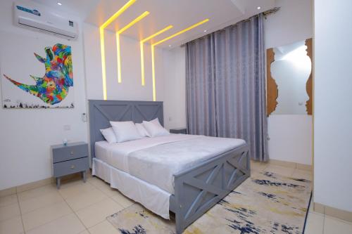 a bedroom with a bed and a painting on the wall at 3 bedrooms Entebbe Lake-House with Pool,Private Beach, Kids Park and AC in Kagolomolo