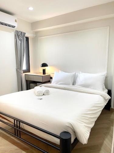a bedroom with a large bed with white sheets and pillows at RESET at DMK Hotel in Don Muang Airport