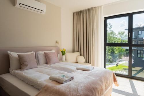 a bedroom with a large bed with two towels on it at Laguna Beskidów Resort - Studio Sultanit in Zarzecze