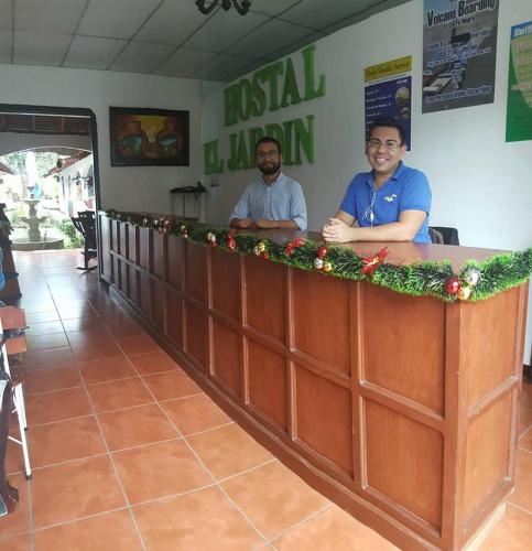 two men sitting at a bar with christmas decorations at Hostal El Jardin in León