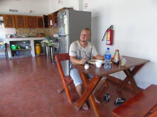 a man sitting at a table in a kitchen at Hostal El Jardin in León