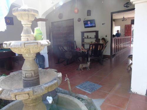 a stone fountain in the middle of a living room at Hostal El Jardin in León
