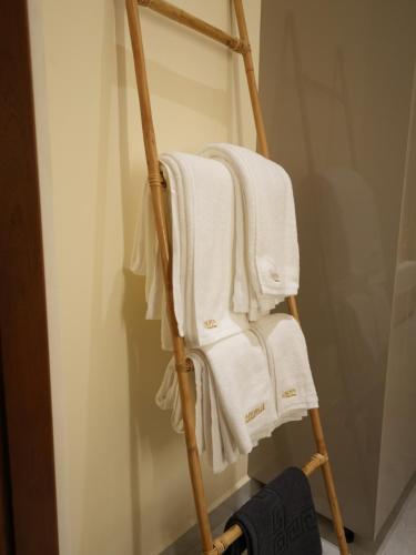 a towel rack with four white towels on it at Lumora Fresh Wave Arugambay in Arugam Bay